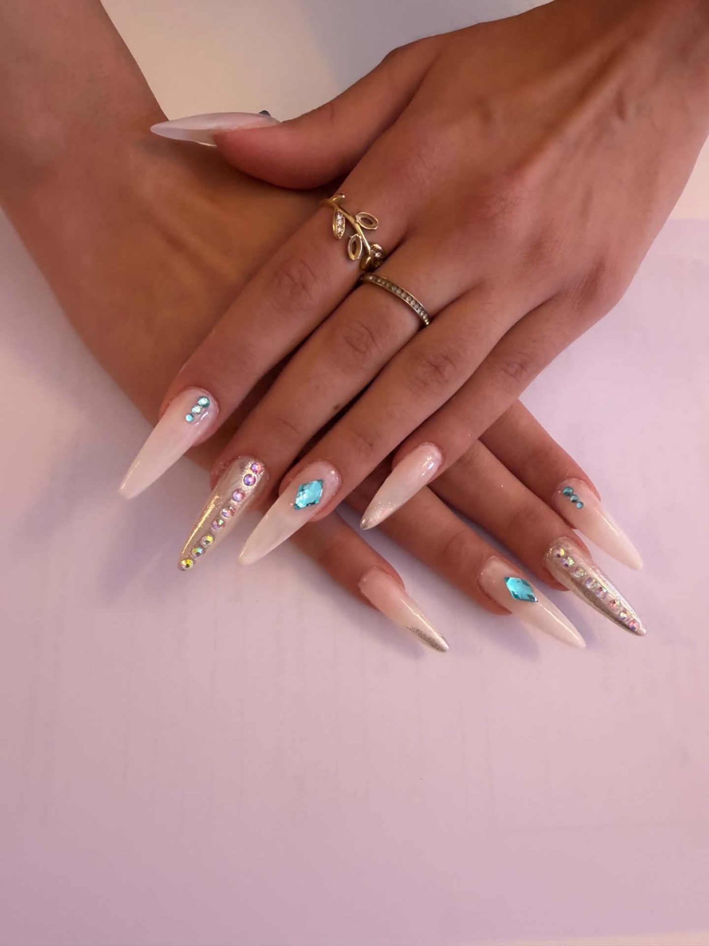 Long stiletto nails in soft nude with crystal detailing